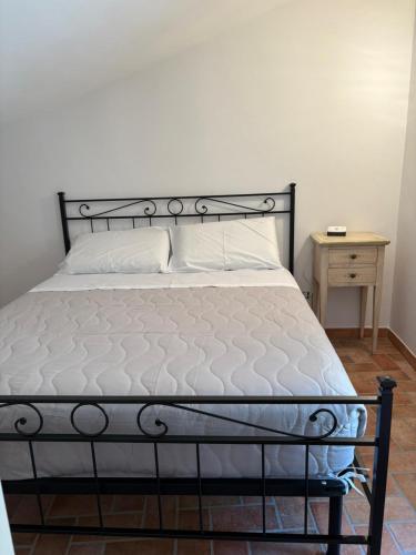 a bed with a black frame and a white mattress at B&B Colle Alto in Carovilli