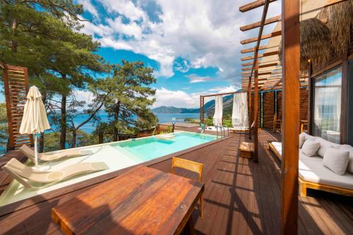 a house with a swimming pool and a deck at Lov Faralya Adults Only in Faralya