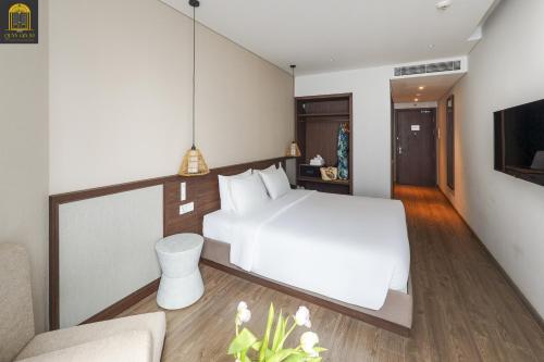 a bedroom with a white bed and a couch at Apec Mandala Wyndham Mui Ne Ngoc Linh in Mui Ne