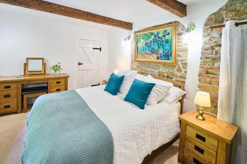 une chambre avec un lit et un mur en pierre dans l'établissement Host & Stay - Dipple Farm Cottage, à Woolfardisworthy