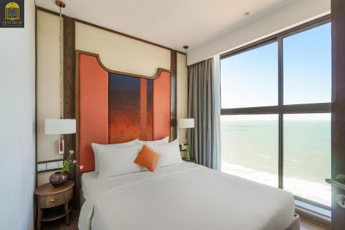 a bedroom with a large bed and a large window at Apec Mandala Wyndham Mui Ne Ngoc Linh in Mui Ne