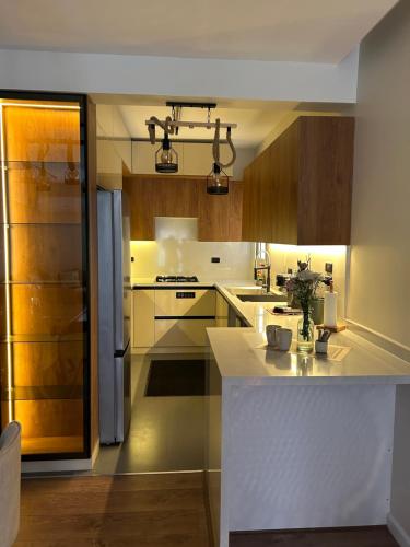 a kitchen with a white counter top and wooden cabinets at Apartment at Mountain View i city October compound in 6th Of October