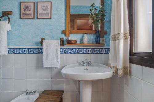 une salle de bain blanche avec un lavabo et un miroir dans l'établissement Casa de Bárbara, à Alcalá de los Gazules