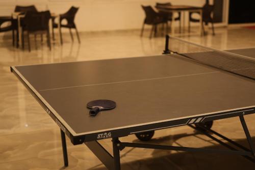 a ping pong table with a ping paddle on it at Gubbi Goodu Green Resort in Bengaluru