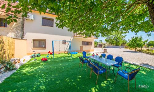 a table and chairs in the yard of a house at Holiday Home Blaz in Ljubuški