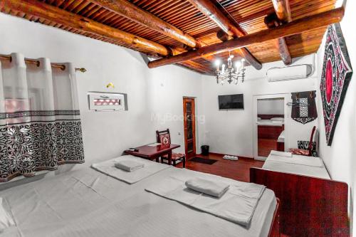 una camera da letto con due letti in una stanza di Ohun historical 16 th century hotel Uzbekistan Bukhara Old sity a Bukhara