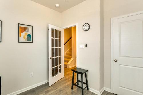 a hallway with a door and a clock on the wall at Frederick Townhome with Balcony, Close to Parks! in Frederick