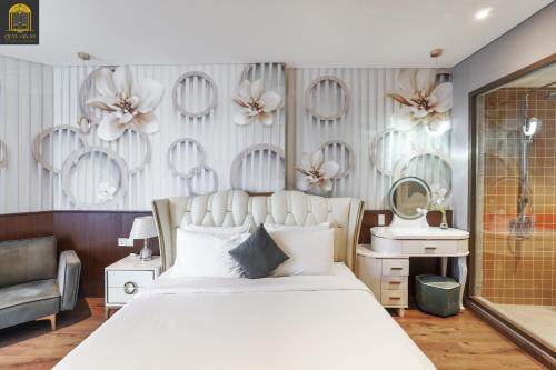 a bedroom with a large white bed and a mirror at Apec Mandala Wyndham Mui Ne Ngoc Linh in Mui Ne
