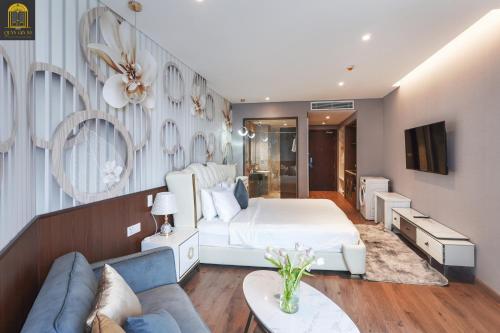 a bedroom with a white bed and a couch at Apec Mandala Wyndham Mui Ne Ngoc Linh in Mui Ne