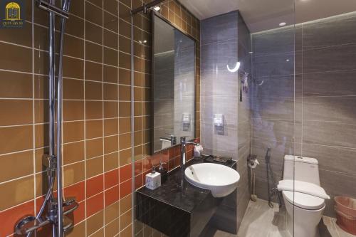 a bathroom with a sink and a toilet in it at Apec Mandala Wyndham Mui Ne Ngoc Linh in Mui Ne