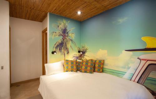 a bedroom with a white bed with a painting on the wall at To live happily live outside surrounded by nature in Estoril