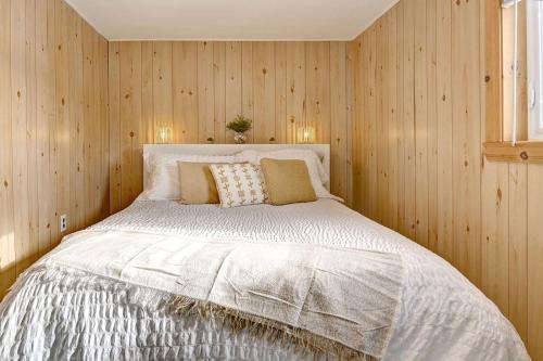 a bedroom with a white bed with wooden walls at Detente Namur in Namur