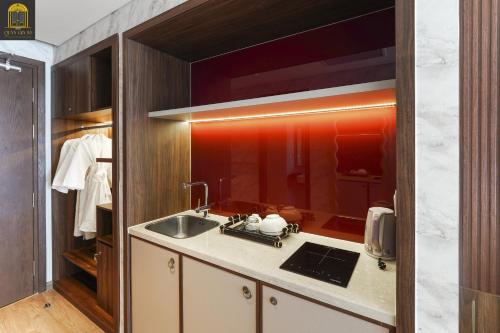 a kitchen with a sink and a mirror at Apec Mandala Wyndham Mui Ne Ngoc Linh in Mui Ne