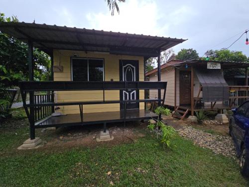 a house with a porch with a roof at Amsyah Roomstay in Pendang