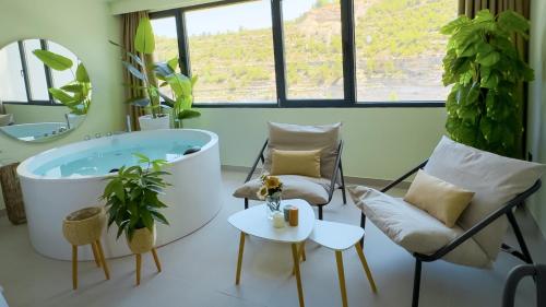 a bathroom with a tub and a chair and a table at Panorama Suites in Jorquera