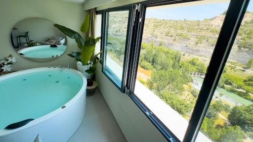 a bathroom with a tub and a large window at Panorama Suites in Jorquera