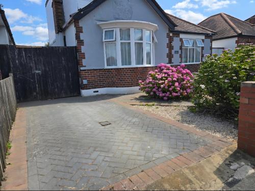 a house with a fence and a brick driveway at Double Room with Ensuite Bathroom in Feltham