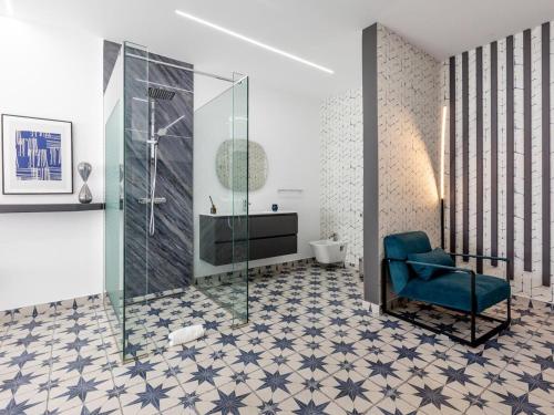 ein Badezimmer mit einer Dusche und einem blauen Stuhl in der Unterkunft Enchanting Villa Alma in Playa Paraiso