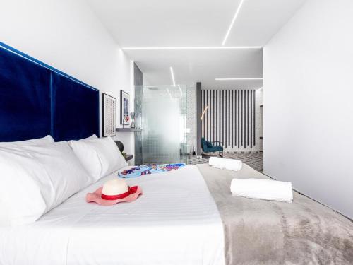 ein Schlafzimmer mit einem weißen Bett mit Hut darauf in der Unterkunft Enchanting Villa Alma in Playa Paraiso