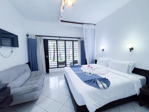 a hotel room with a bed and a chair at Milele Beach Hotel in Bamburi