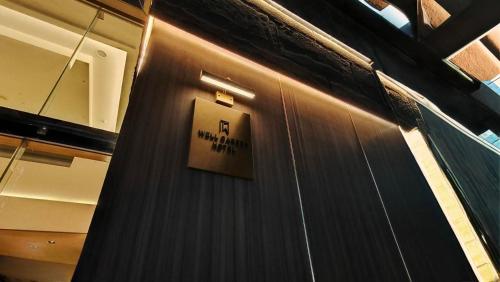 a sign on the side of a wooden wall at Well Garden Hotel in Taoyuan
