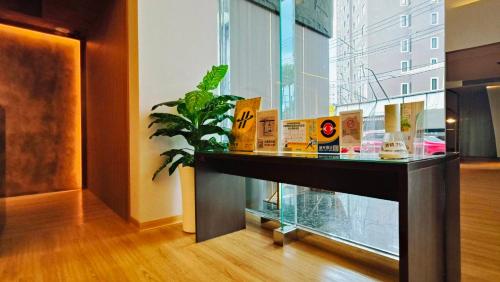 a glass counter in a room with a plant at Well Garden Hotel in Taoyuan
