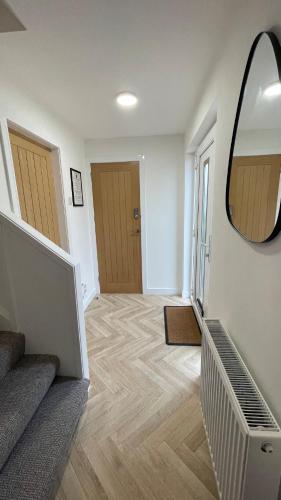 a hallway with a mirror on the wall and a staircase at The Den - by Caithness Luxury Apartments NC500 - 2 Bedroom holiday home - Sleeps Work teams upto 2 & holiday makers upto 4 in Wick