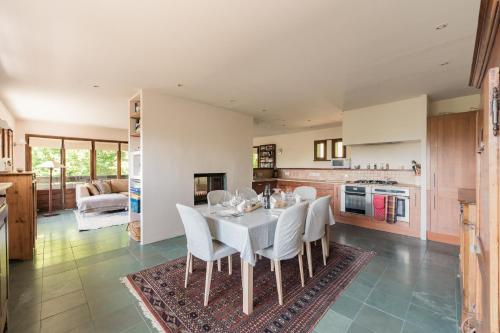 une cuisine et une salle à manger avec une table et des chaises blanches dans l'établissement Chalet l'Arba - Ecrin à la croisée des stations, à Cordon