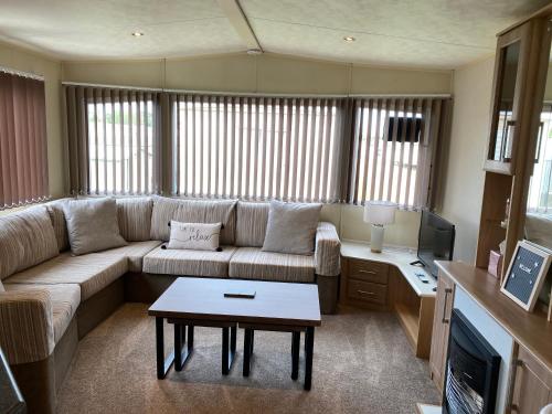 a living room with a couch and a table at 6 berth caravan hire close to Fantasy Island in Ingoldmells