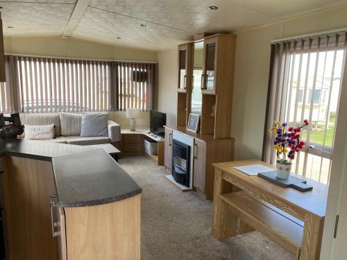 a large living room with a couch and a table at 6 berth caravan hire close to Fantasy Island in Ingoldmells