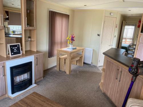 a living room with a fireplace and a table at 6 berth caravan hire close to Fantasy Island in Ingoldmells