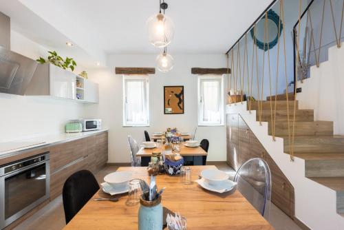 a dining room with a table and chairs and a staircase at Il riccio di Ricciano in Casale Corte Cerro