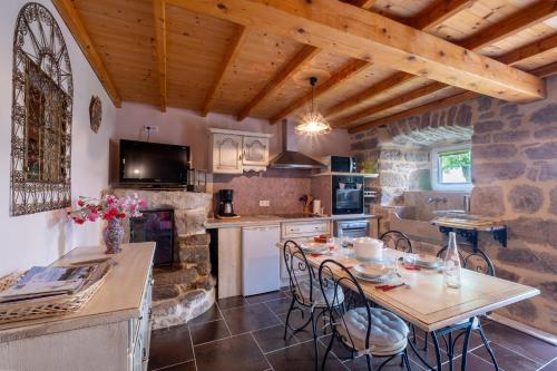une cuisine avec une table et des chaises dans une pièce dans l'établissement Gîte La Campone 2/4 personnes, à Montbel