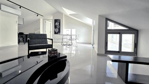 a white living room with a table and chairs at Tabarja Hills apartment in ‘Ayn aş Şughayrah