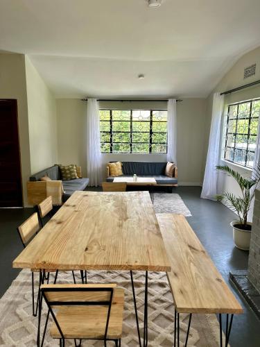 a living room with a wooden table and a couch at Open Gate House in Arusha