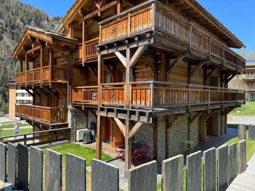 a large wooden building with balconies on it at Polaris 1 004 LUXE & SKI LIFT apartment 6 pers in Zinal