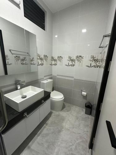 a white bathroom with a sink and a toilet at Quest by Entrance in Feydhoo