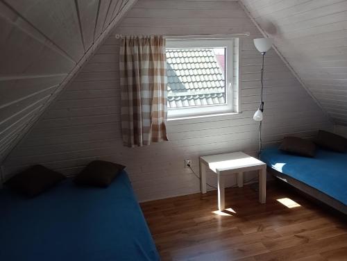 a room with two beds and a table and a window at Bałtyckie Siedlisko in Jarosławiec
