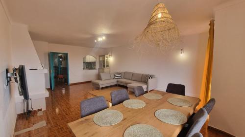 ein Wohnzimmer mit einem Tisch und einem Sofa in der Unterkunft Ericeira Breeze Villa in Ericeira