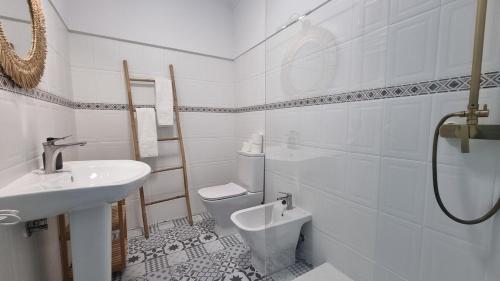 ein weißes Badezimmer mit Waschbecken und Toilette in der Unterkunft Ericeira Breeze Villa in Ericeira