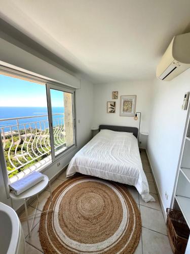 une chambre avec un lit et une grande fenêtre dans l'établissement Bohème Beach Villa with seaview & private garden, Antheor, à Saint-Raphaël