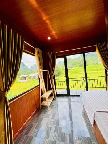 Yên MinhにあるDu Già Bungalowのベッドと大きな窓のある寝室