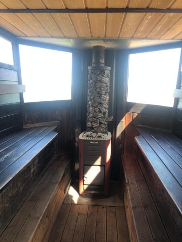 an empty cabin with two benches and a stone stove at Pusi Holiday House in Pusi