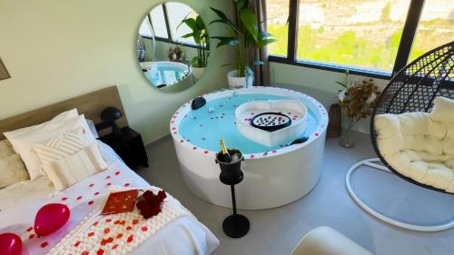 a room with a bath tub with a bed and a mirror at Panorama Suites in Jorquera