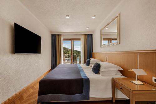 una camera d'albergo con un letto e una televisione di Villa Malo More a Dubrovnik