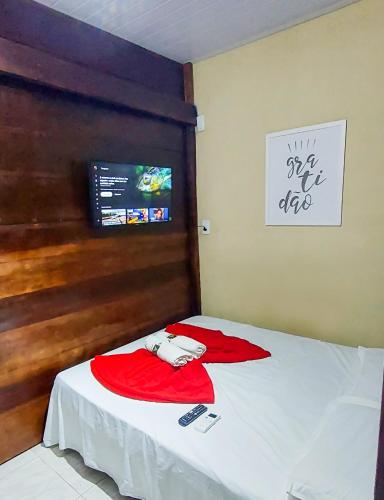 a room with a bed with a red shirt on it at Chalé Madeira Nobres Asa Própria in Estivado