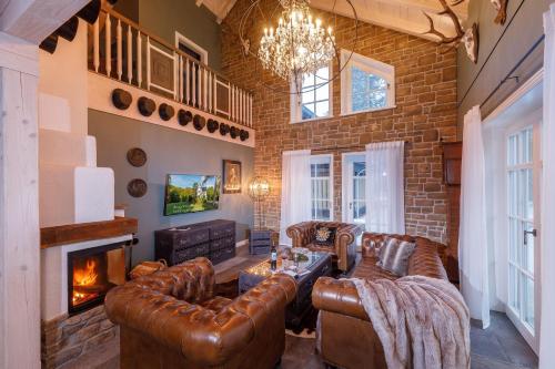 a living room with leather furniture and a fireplace at Landhaus-Gutshaus in Ilsenburg