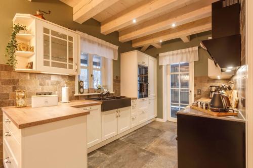 a kitchen with white cabinets and a black refrigerator at Landhaus-Gutshaus in Ilsenburg