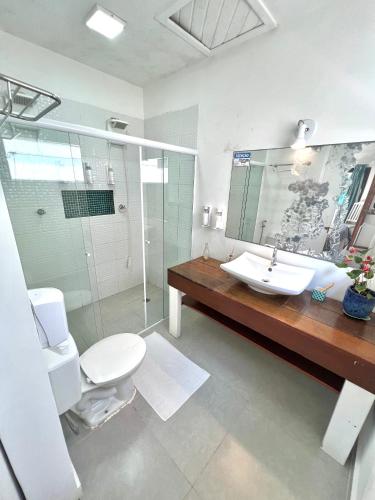 a bathroom with a toilet and a sink and a shower at Pousada Tô na Praia Juquehy in Juquei