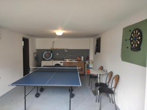 a ping pong table in a room with chairs at Kuća za odmor "Villa Merkur" - Orahovica in Orahovica